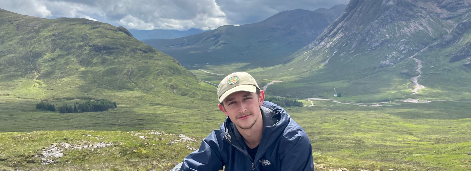 Luc in de natuur met bergen op de achtergrond