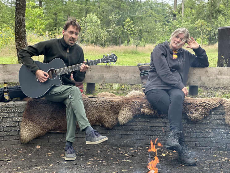 Paul speelt gitaar bij het kampvuur