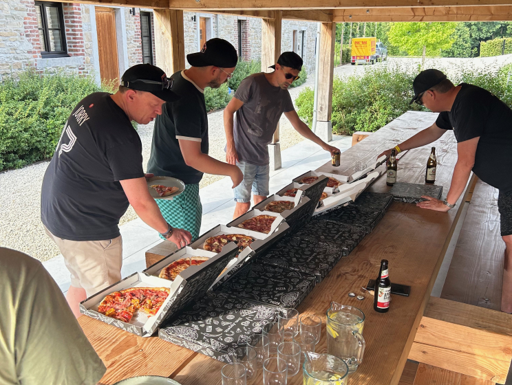 Team van Flink pakt een puntje pizza onder de houten overkapping