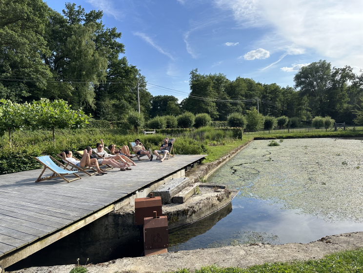 Team van Flink in de zon op het houten dek aan de vijver