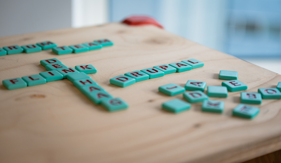 Steentjes met letters liggen op een houten tafel