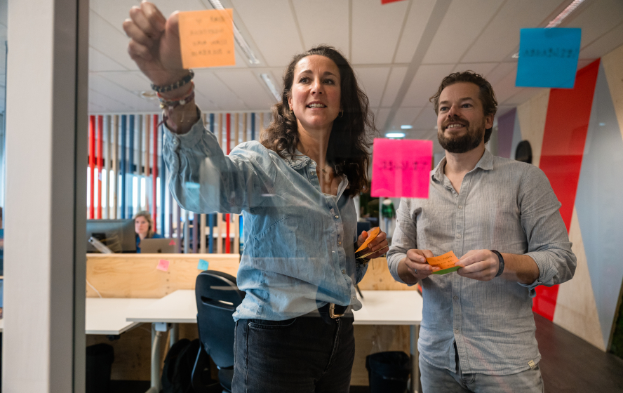 Daisy en Sebastiaan plakken post-its tijdens overleg